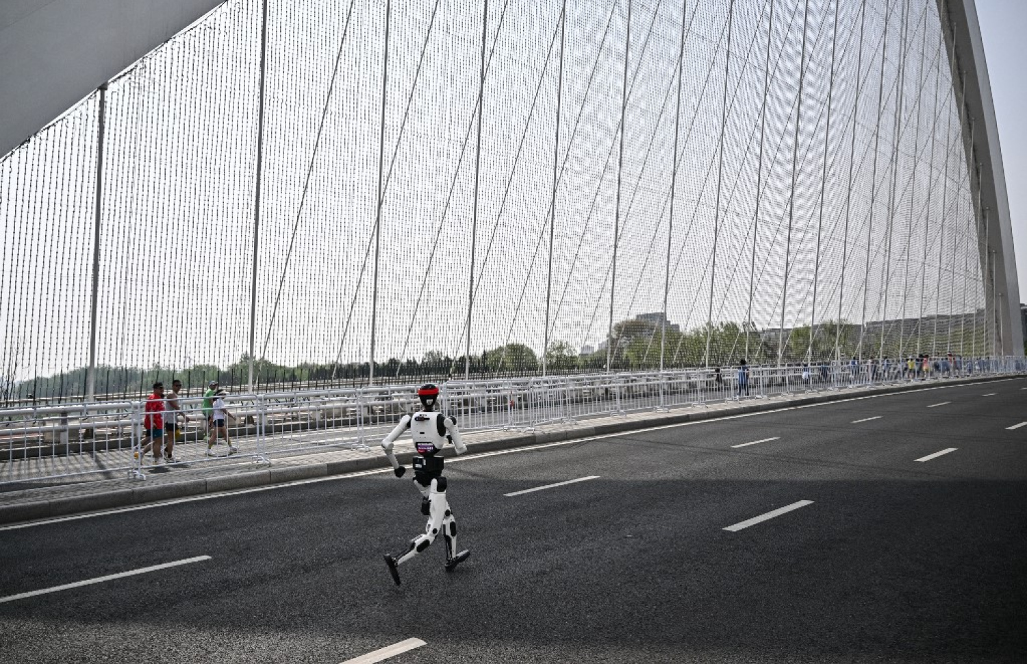 ބެއިޖިންގްގައި ބޭއްވި ދެވަނަ ބެއިޖިންގް އީ-ޓައުން ހާފް މެރަތަން އަދި ހިއުމަނޮއިޑް ހާފް މެރަތަންގައި ރޮބޮޓެއް ދުވަނީ. --- ފޮޓޯ: ޕެޑްރޯ ޕާޑޯ | އޭއެފްޕީ