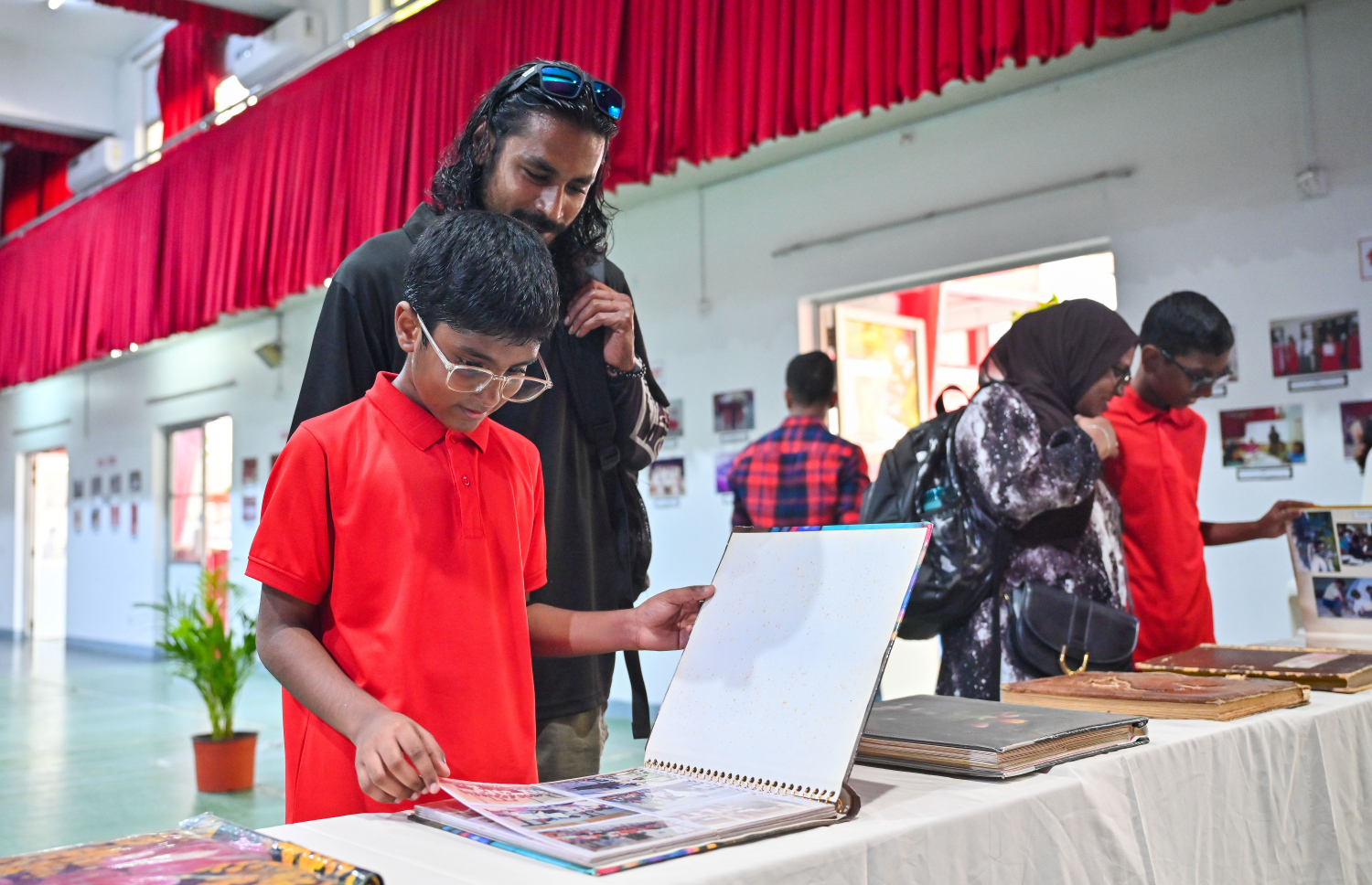 އިސްކަންދަރު ސްކޫލުގެ އަހަރީ ދުވަސް ފާޙަގަކުރަން އެ ސްކޫލުގައި ހުޅުވި ފޮޓޯ އެގްޒިބިޝަންގައި ކުއްޖަކު ފޮޓޯތަކެއް ބަލަނީ.-- ފޮޓޯ: ފަޔާޒު މޫސާ މިހާރު