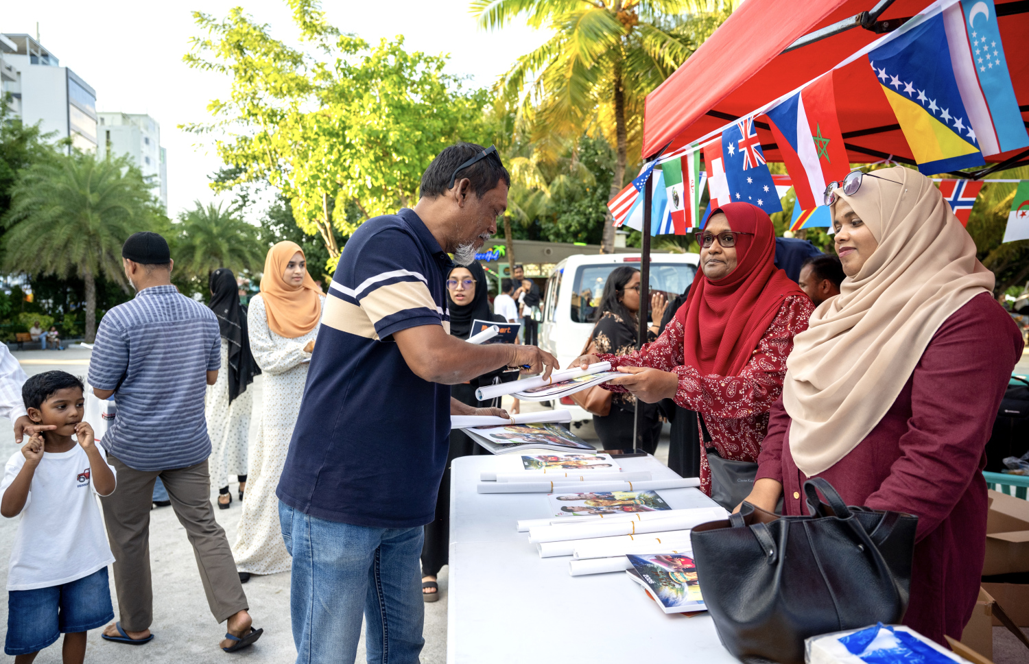 "މިހާރު" ގެ ވޯލްޑް ކަޕް ގައިޑް ހޯދަން ބަޔަކު ކިޔުގައި ޖެހިގެން --- ފޮޓޯ: ނިޝާން އަލީ | މިހާރު
