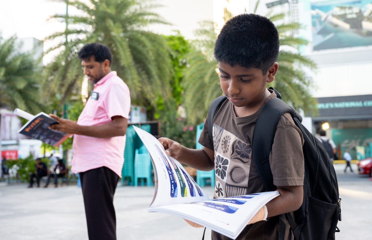 "މިހާރު" ވޯލްޑް ކަޕް ފޮތް، ކުޑަކުއްޖަކު ބަލަހައްޓައިގެން --- ފޮޓޯ: ނިޝާން އަލީ | މިހާރު