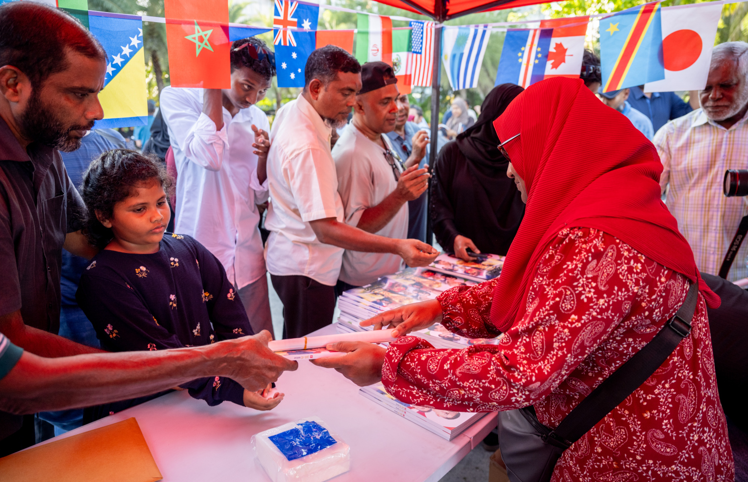 "މިހާރު" ގެ ވޯލްޑް ކަޕް ގައިޑް ހޯދަން ގިނަ އަދަދެއްގެ ބަޔަކު ކިޔުގައި ޖެހިގެން --- ފޮޓޯ: ނިޝާން އަލީ | މިހާރު