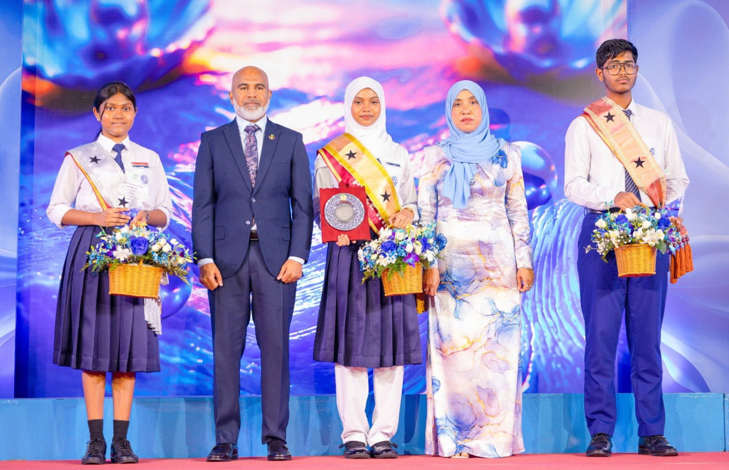 އަމީނިއްޔާ ސްކޫލުގެ އިނާމު ދިނުމުގެ ޖަލްސާގައި އެންމެ މޮޅު ދަރިވަރުންނާ އެކު އެ ސްކޫލުގެ ޕްރިންސިޕަލް ރިންޒީ ވަހީދު އަދި އެޑިއުކޭޝަން މިނިސްޓަރު އިސްމާއިލް ޝަފީއު ފޮޓޯއަކަށް ހުއްޓިވަޑައިގެން.-- ފޮޓޯ: އަމީނިއްޔާ ސްކޫލު