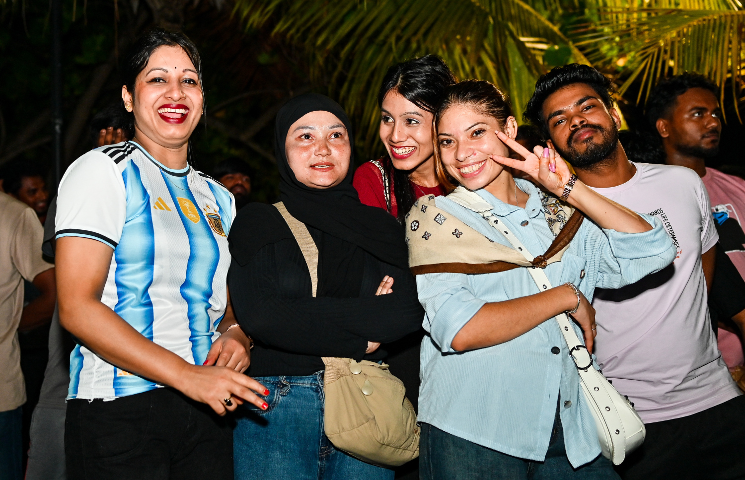 ވޯލްޑްކަޕުގައި އާޖެންޓީނާ ކުޅުނު މެޗު ބަލަން އާޓިފިޝަލް ބީޗު ސަރަހައްދުގައި އާޖެންޓީނާގެ ބައެއް ސްޕޯޓަރުން ފޮޓޯއަކަށް ހުއްޓިލައިގެން -- ފޮޓޯ: ފަޔާޒު މޫސާ | މިހާރު