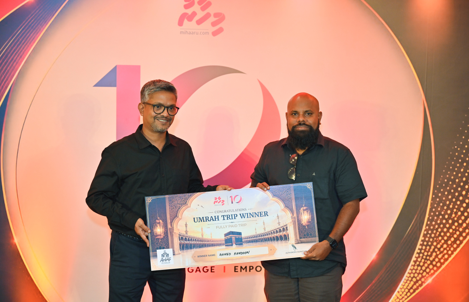 "މިހާރު" ނޫހުގެ 10 ވަނަ އަހަރީ ދުވަސް ފާހަގަކުރަން ބޭއްވި ހަފްލާގައި ގުރުއަތުން އުމްރާ ދަތުރު ލިބުނު އެޑިޓަރު އަހުމަދު ހަމްދޫނަށް ރަމްޒީކޮށް އުމްރާ ދަތުރު ލިބުނު ކަމުގެ ލިޔުން ހަވާލުކުރަނީ.--- ފޮޓޯ: މިހާރު