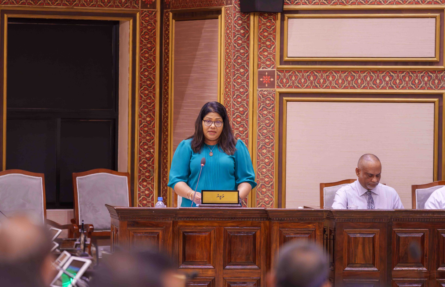 ހެލްތު މިނިސްޓަރު ގީލާ އަލީ މަޖިލީހުގެ ޖަލްސާގައި ވާހަކަ ދައްކަވަނީ.-- ފޮޓޯ: މަޖިލިސް