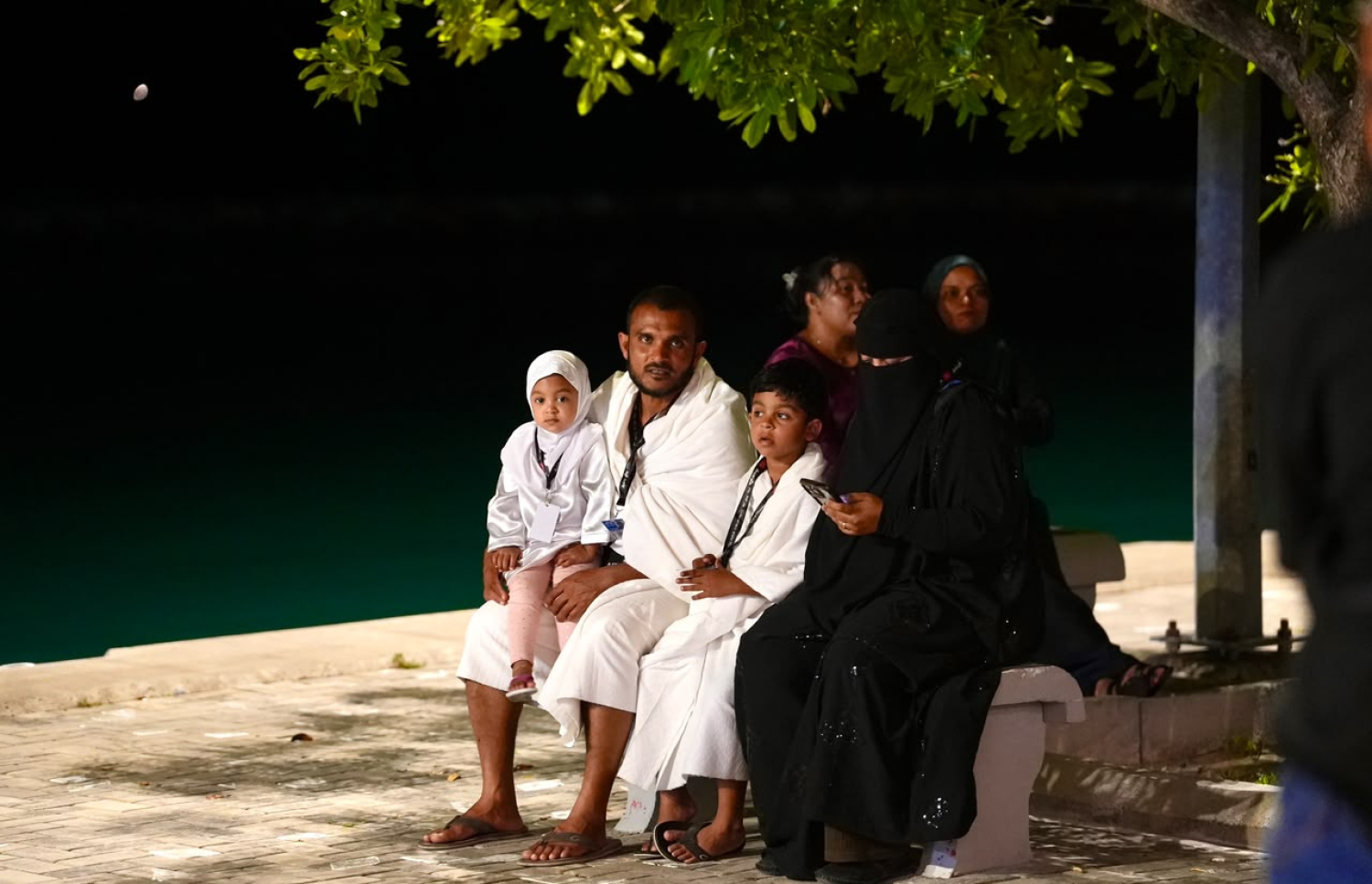 އައްޑޫ ގަމުން ރޭ ފަތިހު އުމްރާގެ އަޅުކަމަށް ފުރި އާއިލާއެއްގެ ބަޔަކު ފުރުމުގެ ކުރިން ގަން އެއާޕޯޓުގެ ބޭރުގައި ފޮޓޯއެއް ނަގަނީ.---ފޮޓޯ: މިހާރު