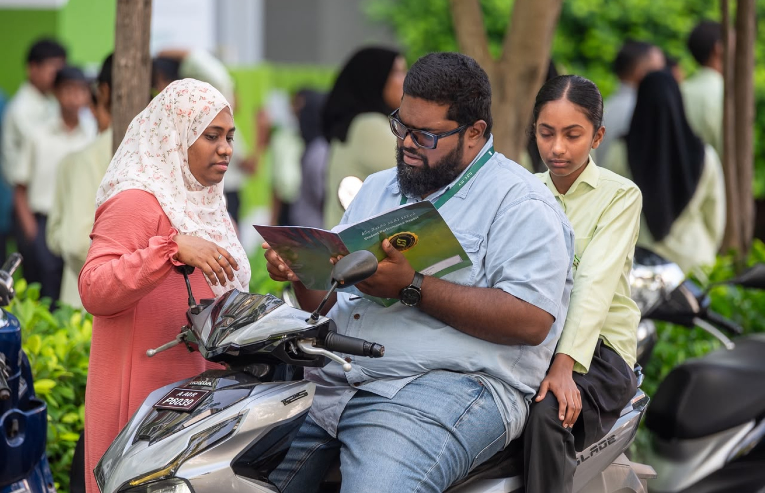 ހުރަވީ ސްކޫލުގެ ދަރިވަރަކު ބެލެނިވެރިންނާއެކު ރިޕޯޓުފޮތް ބަލަނީ-- ފޮޓޯ: ފަޔާޒް މޫސާ / މިހާރު