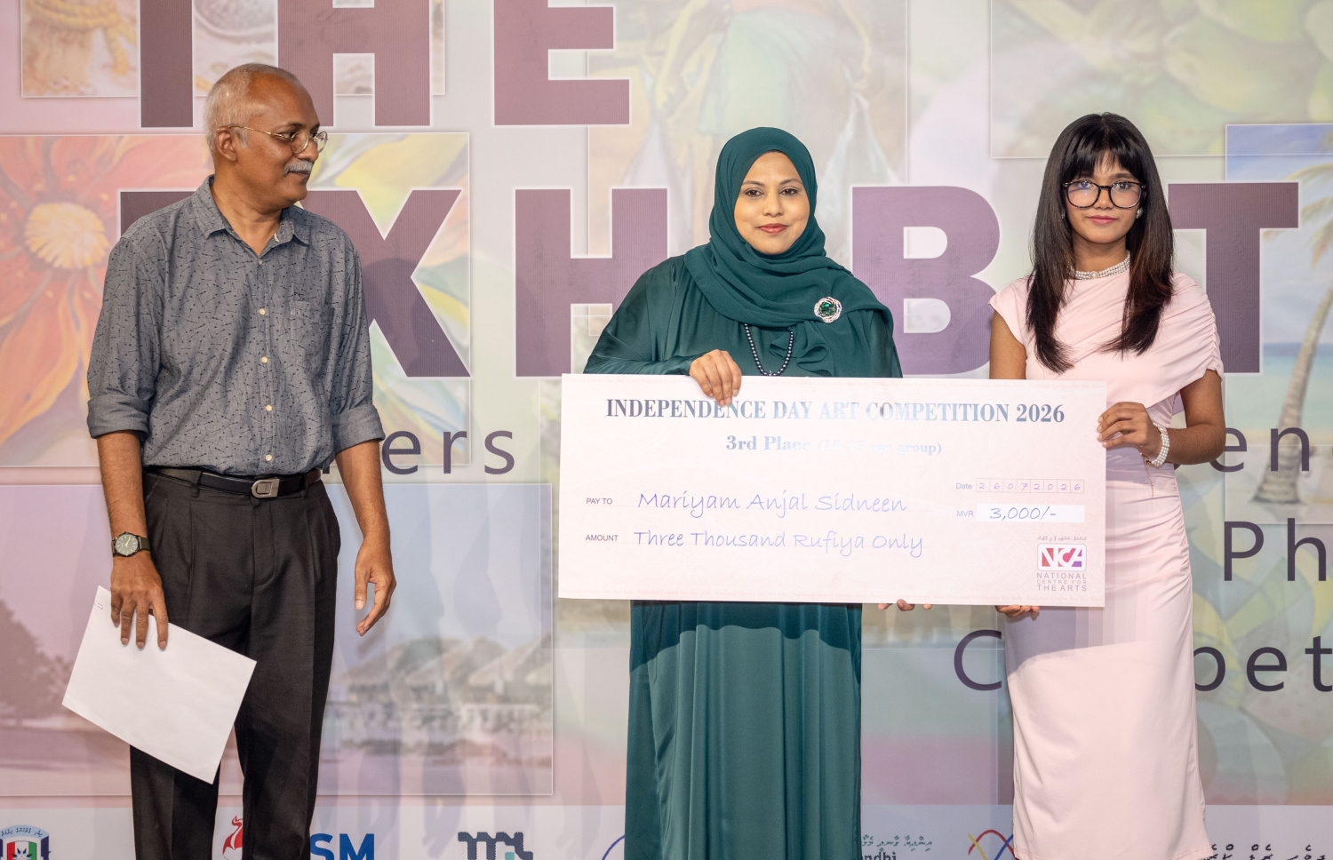 ރާއްޖޭގެ 61 ވަނަ މިނިވަންދުވަސް ފާހަގަކުރުމަށްޓަކައި ނޭޝަނަލް ސެންޓަފޯ ދި އާޓްސް އިން ބޭއްވި ކުރެހުމުގެ މުބާރާތުގައި އުމުރުން 16 އަހަރާއި 20 އަހަރާ ދެމެދު އުމުރު ފުރައިން ތިން ވަނައަށް ހޮވުނު މަރިޔަމް އަންޖަލް ސިދްނީންއަށް ފައިސާގެ އިނާމު ހަވާލުކުރަނީ.--- ފޮޓޯ: ފަޔާޒު މޫސާ | މިހާރު