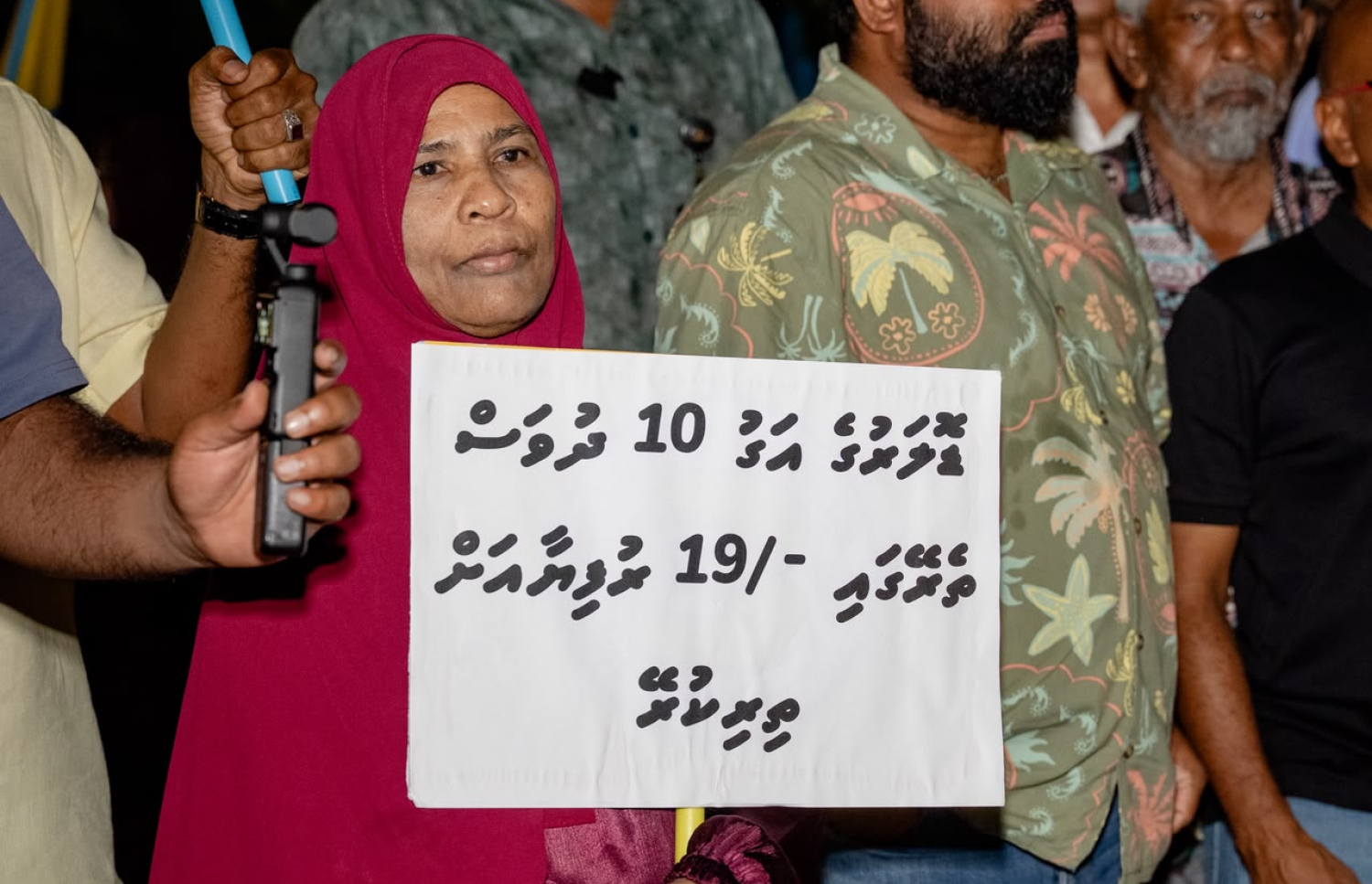 ޑޮލަރުގެ މައްސަލައާ ގުޅިގެން ރޭ ބޭއްވި އެއްވުމުގައި މީހަކު ބޯޑެއް ހިފަހައްޓައިގެން.-- ފޮޓޯ: ފަޔާޒު މޫސާ/ މިހާރު