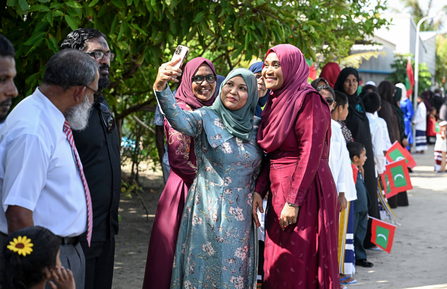 ގައުމީ ދުވަހުގެ ރަސްމީ ޖަލްސާ އަށް ހއ. އުތީމަށް ވަޑައިގެން އެ ރަށުގެ މީހަކާ އެކު ފަސްޓް ލޭޑީ ސާޖިދާ މުހައްމަދު ފޮޓޯއެއް ނަންގަވަނީ.--- ފޮޓޯ: ރައީސް އޮފީސް