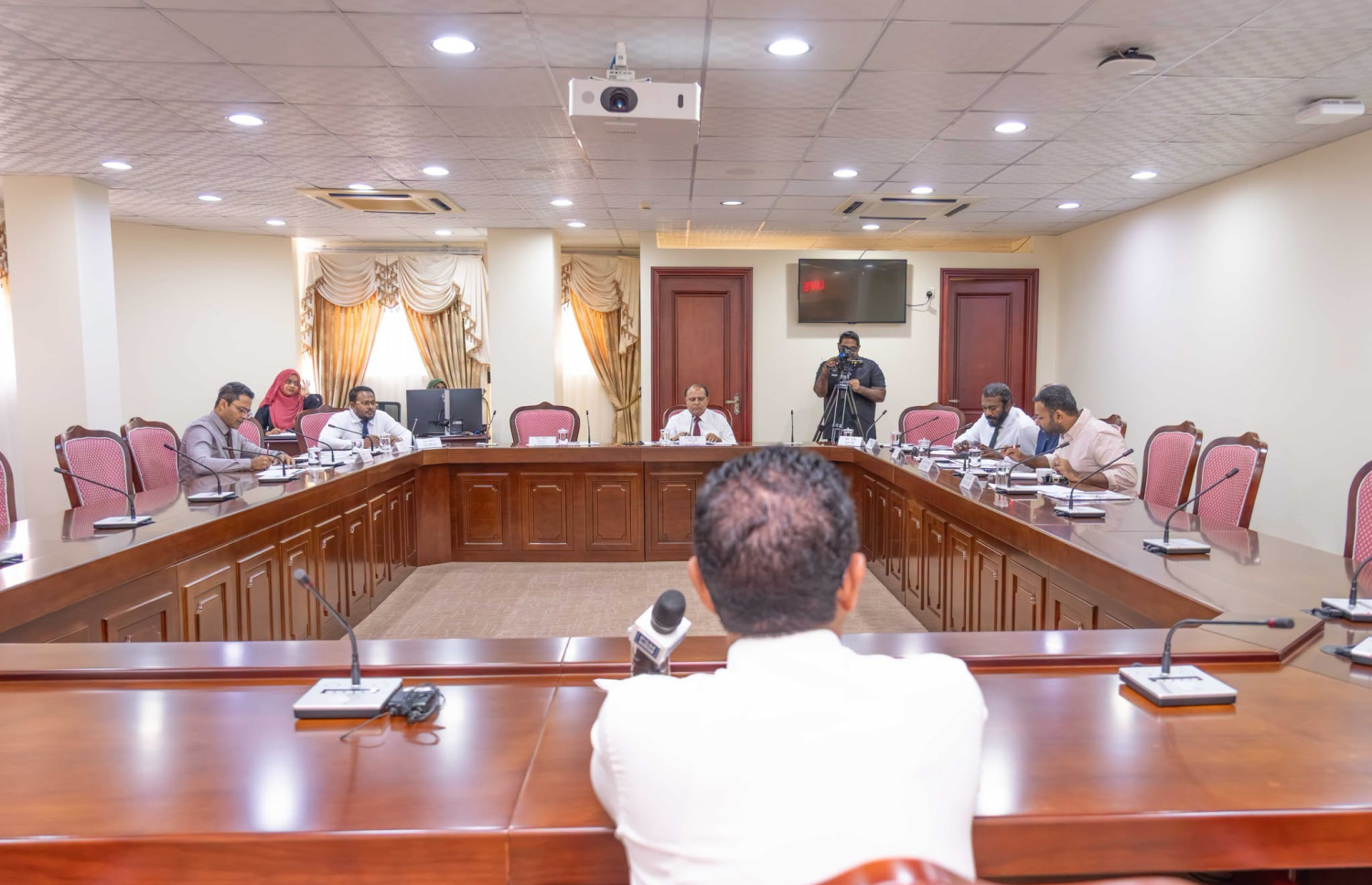 ރައްޔިތުންގެ މަޖިލީހުގެ މިނިވަން މުއައްސަސާތަކުގެ ކޮމިޓީގެ މެމްބަރުން ކުރެއްވި ސުވާލުތަކަށް އަބްދުލް އަޒީޒް ޖަމާލް އަބޫބަކުރު ޖަވާބުދެއްވަނީ. ފޮޓޯ: މަޖިލީހުގެ އިދާރާ