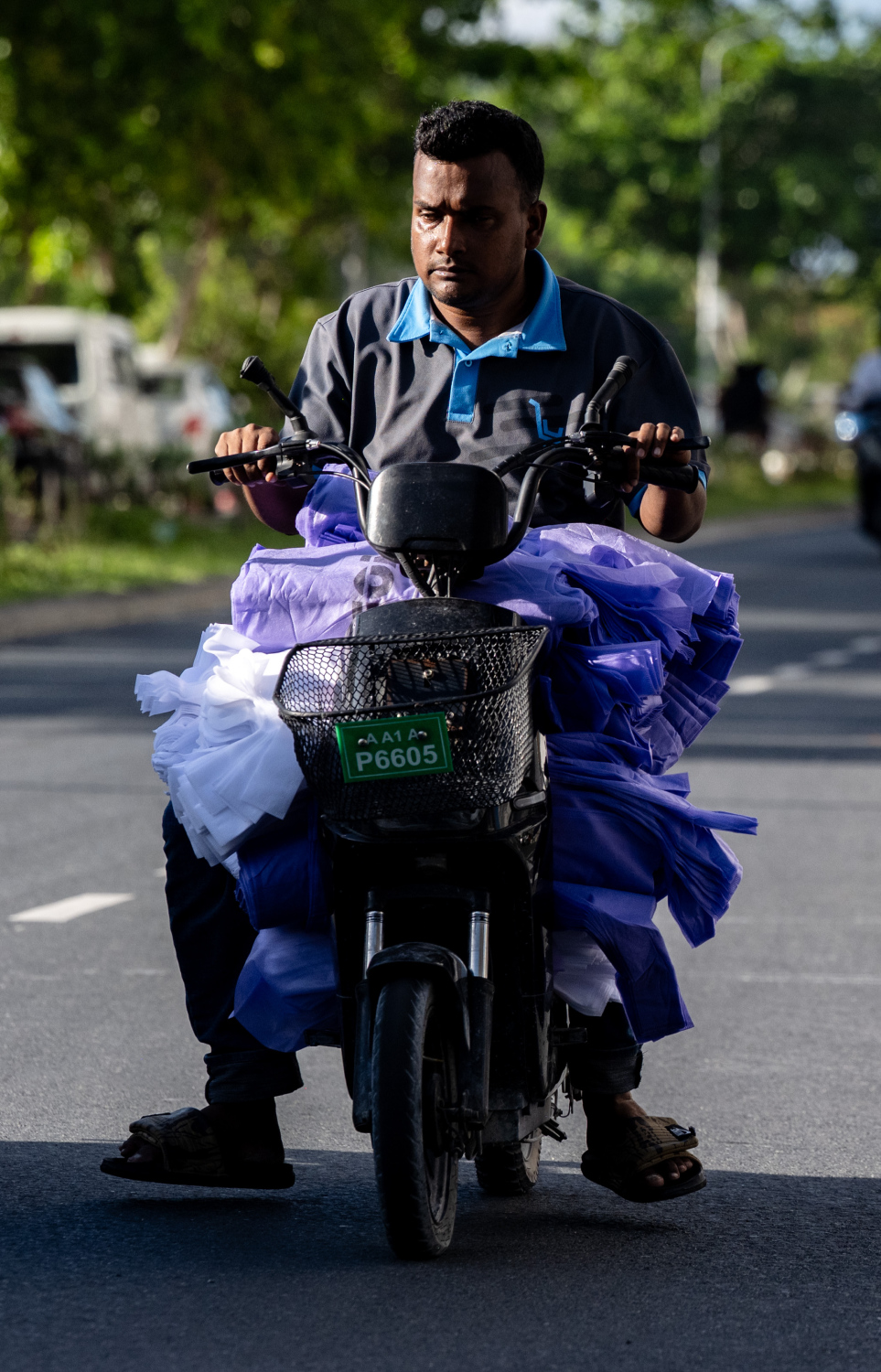 ބިދޭސީ މީހަކު ބެޓެރީ ސައިލެއްގައި ގިނަ އަދަދެއްގެ މުދާ އަރުވައިގެން ދަނީ: މި ގޮތަށް ސައިކަލްގައި މުދާ އުފުލައިގެން ދަތުރު ކުރުމަކީ މަނާކަމެއް.--- ފޮޓޯ: ފަޔާޒު މޫސާ | މިހާރު