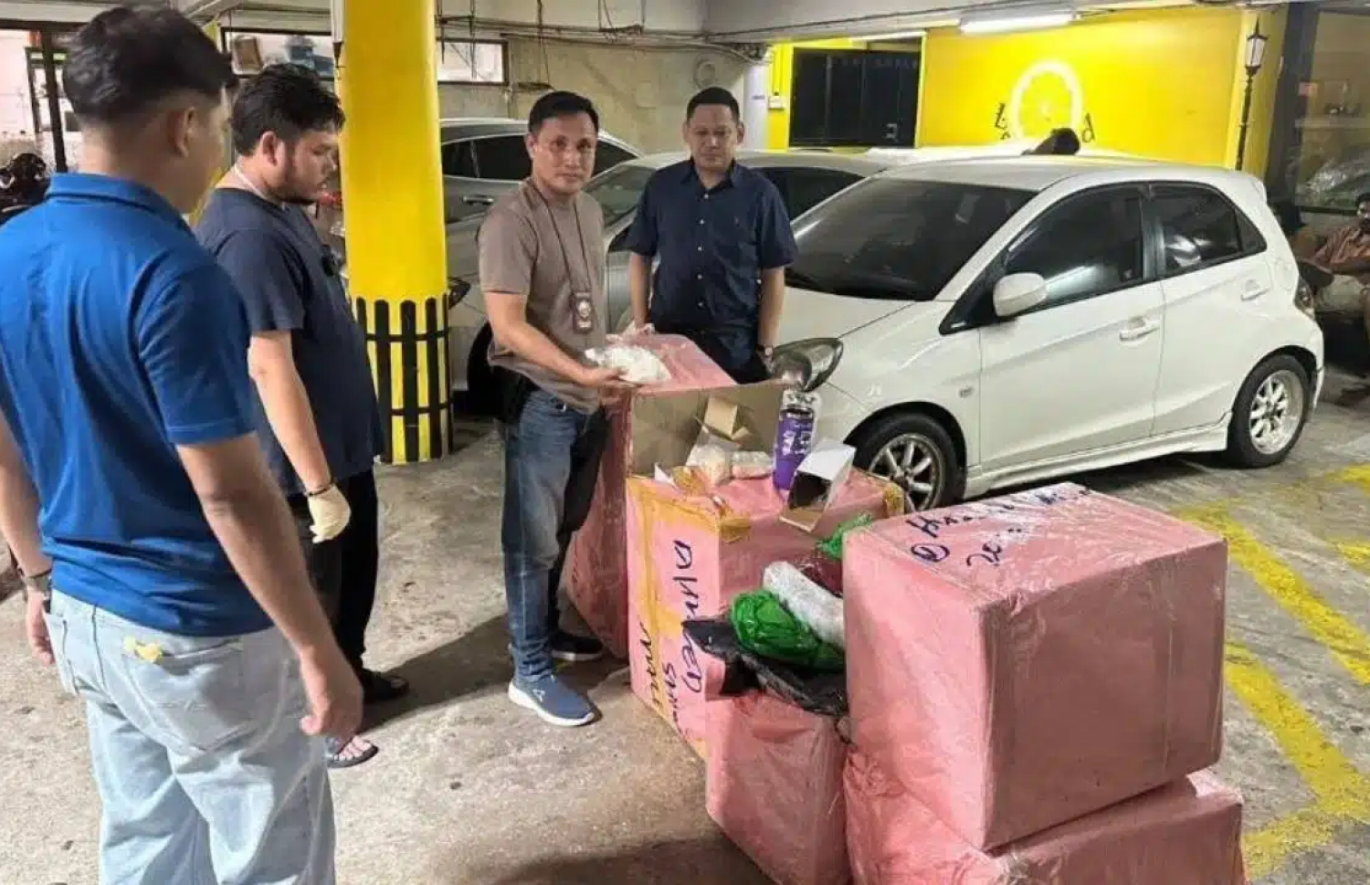 މަސްތުވާތަކެތި ބަންދުކޮށްފައި ހުރި ޕާރުސަލްތައް ފުލުހުން ބަލަނީ.-- ފޮޓޯ: ތައި ޕޮލިސް