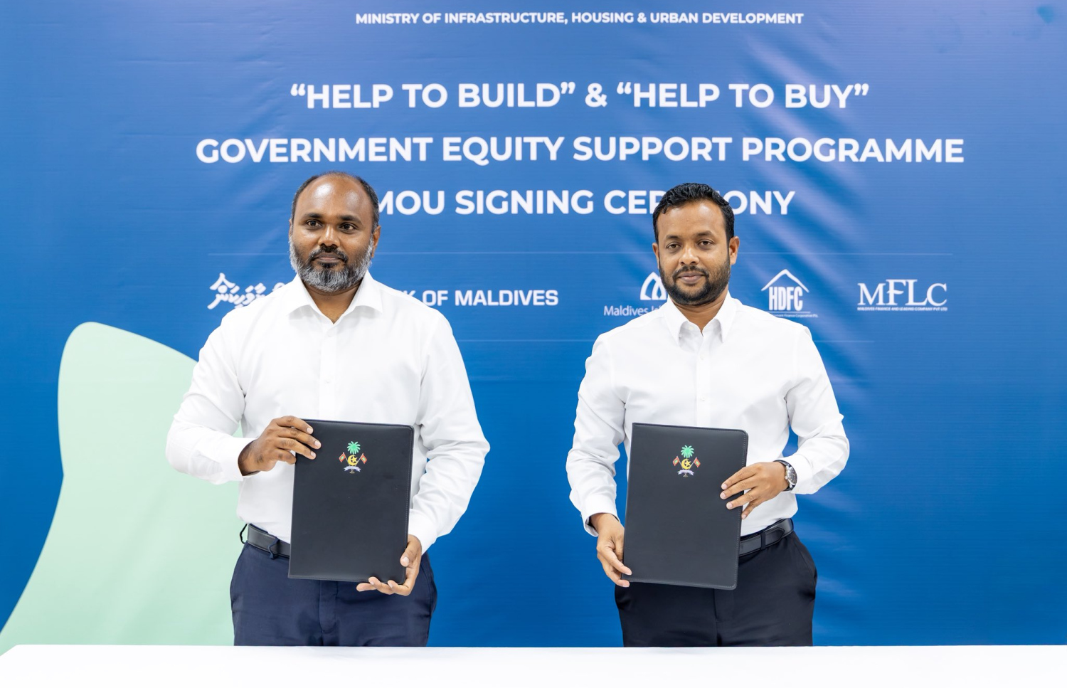 ގެދޮރު ލޯނަށް އިކުއިޓީ ދޭ ޕްރޮގްރާމްގެ އެމްއޯޔޫއެއްގައި ސޮއިކުރެއްވުމަށް ފަހު ފޮޓޯއަކަށް ހުއްޓިގެން. -- ފޮޓޯ: ހައުސިން މިނިސްޓްރީ