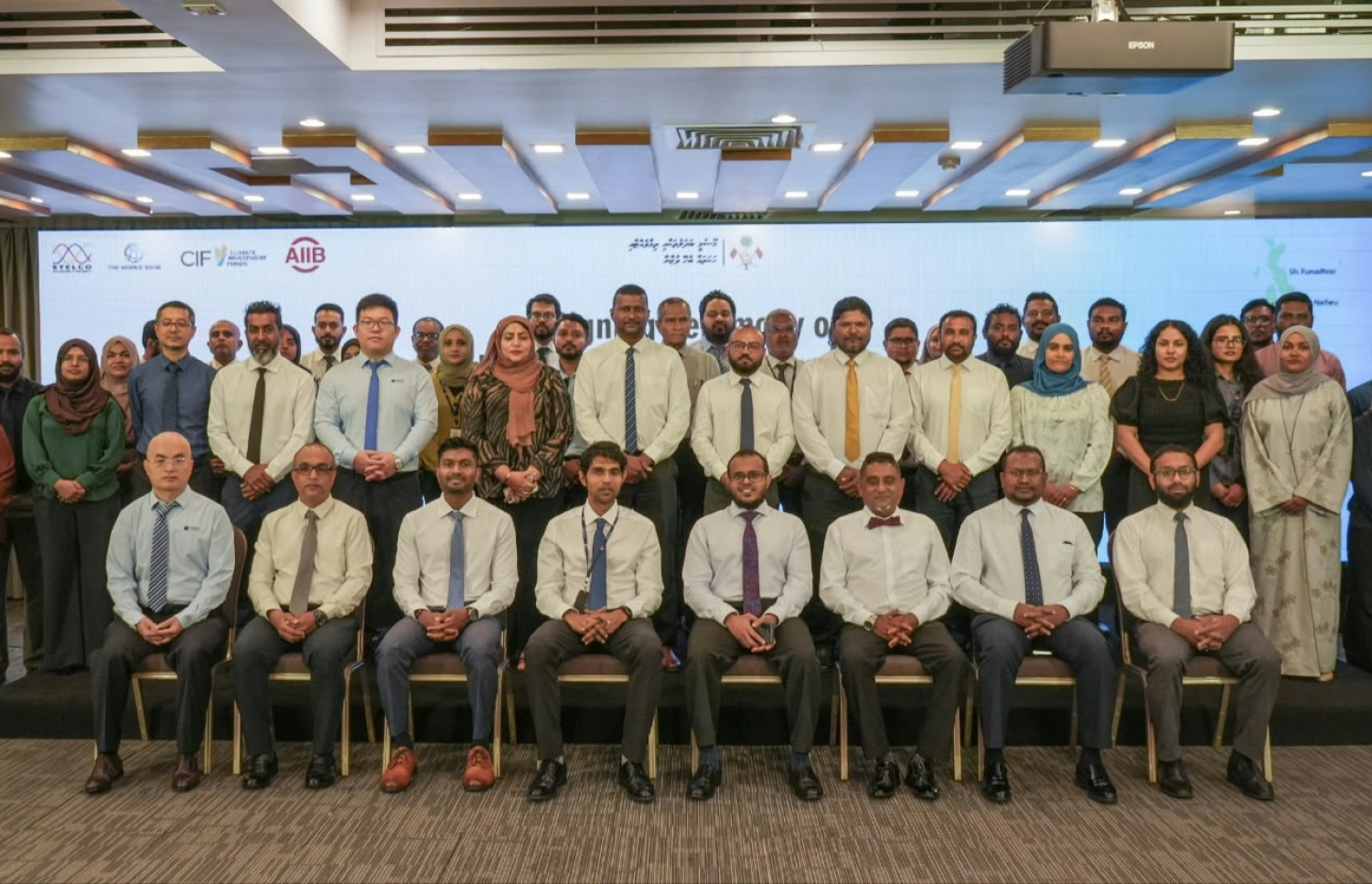 15 މެގަވޮޓްގެ އިޔާދަކުރަނިވި ހަކަތައިގެ ބޮޑު މަޝްރޫއެއްގައި ސޮއިކުރުމަށް ބޭއްވި ރަސްމިއްޔާތުގެ ބައިވެރިން ފޮޓޯއެއް ނަގަނީ.-- ފޮޓޯ: ތިމާވެއްޓާ ބެހޭ މިނިސްޓްރީ